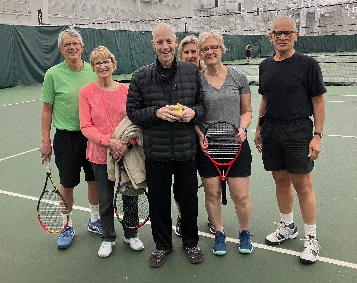 Photo of Coach Dan Steiner with Tom and others on the tennis court.